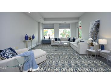 Open living room featuring a plush sectional sofa, stylish rug, and large windows at 400 W North St # 620, Raleigh, NC 27603