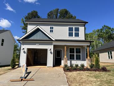 Charming two-story home featuring light gray siding, an attached garage, and manicured front landscaping at 406 Maidenhair Pl, Clayton, NC 27520
