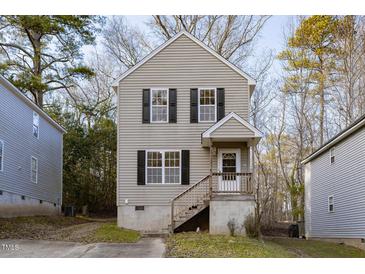 Two-story house with beige siding, black shutters, and a small front porch at 412 N Cooper St, Clayton, NC 27520