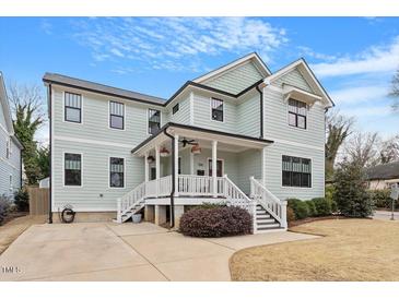 Charming two-story home with a covered front porch, manicured landscaping, and light-colored siding at 700 Coleman St, Raleigh, NC 27610