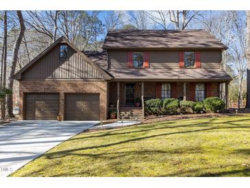 Charming two-story home featuring a well-manicured lawn, brick accents, and a two-car garage with an extended driveway at 11509 Hardwick Ct, Raleigh, NC 27614