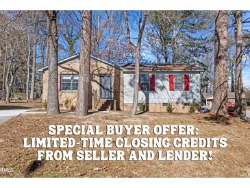 Charming single-story home featuring a brick facade, bright red shutters, and mature trees at 2400 Keith Dr, Raleigh, NC 27610