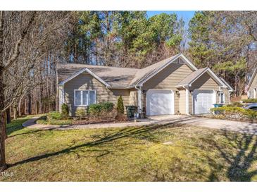 Tan house with two-car garage and landscaped yard at 4118 Pin Oak Dr, Durham, NC 27707