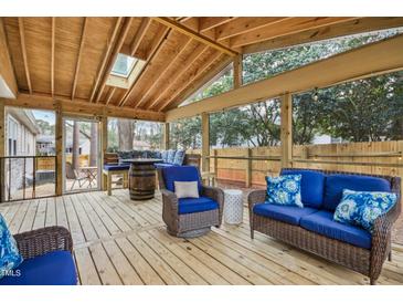 Inviting sunroom with skylight, cozy seating, wooden floors, and beautiful backyard views, perfect for relaxation at 5920 Whittier Dr, Raleigh, NC 27609