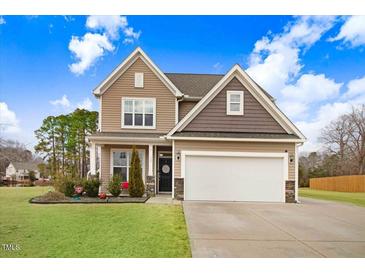 Two-story house with a large garage and landscaped lawn at 130 Daniel Farm Dr, Benson, NC 27504