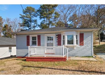 Ranch style home with red shutters, front porch, and brick steps at 3817 Booker Ave, Durham, NC 27713