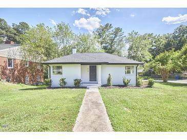 Charming white brick ranch house with a well-manicured lawn at 713 Hudson Ave, Durham, NC 27704