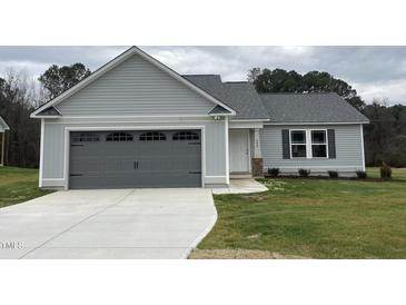 New single-story home with gray siding, a two-car garage, and a well-manicured lawn at 395 Magnolia Run Way, Benson, NC 27504