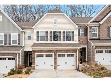 Two-story townhome with beige vinyl siding, two-car garage, and landscaping at 505 Great Eno Path, Hillsborough, NC 27278