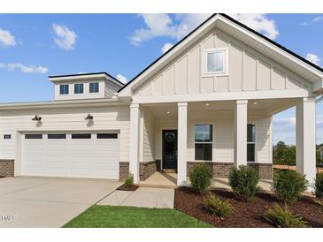 Beautiful home exterior with a well-manicured lawn, covered entrance, and attached garage at 640 Gainer Dr # 21, Raleigh, NC 27610
