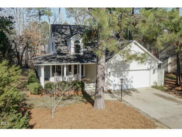 Charming home featuring a quaint front porch with rocking chairs and an attached two-car garage at 2312 Knollwood Dr, Sanford, NC 27330