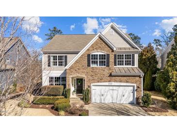 Charming two-story home with a combination of stone and siding, featuring a well-manicured lawn and attached two-car garage at 305 Covenant Rock Ln, Holly Springs, NC 27540