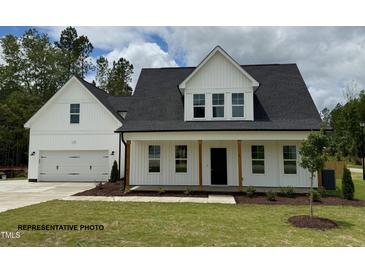 Charming two-story home featuring a welcoming front porch, attached two-car garage, and a well-manicured lawn at 3943 Baileys Xrds Rd, Benson, NC 27504