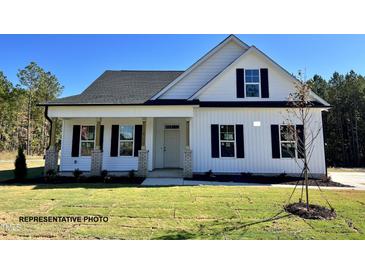 Charming one-story home with white siding, black shutters, covered porch, and well-maintained lawn at 3963 Baileys Xrds Rd, Benson, NC 27504
