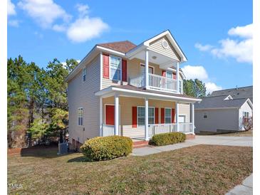 Charming two-story home with double porches, red shutters, and landscaped yard at 5841 Wynmore Rd, Raleigh, NC 27610