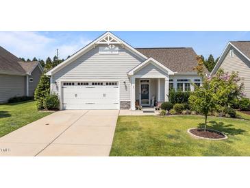 Charming one-story home with a manicured lawn, attached garage, and welcoming front porch at 65 Balsam Ln, Clayton, NC 27527