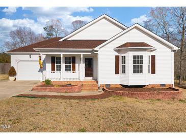 Charming one-story home with white siding, brown shutters, and landscaped front yard at 85 Jarrett Bay Ln, Fuquay Varina, NC 27526