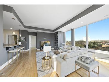 Bright living room featuring hardwood floors, large windows and an open floor plan at 400 W North St # 730, Raleigh, NC 27603