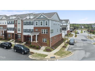 Stylish townhome featuring brick and siding facade with well-maintained landscaping at 547 Gateway Townes Blvd, Wake Forest, NC 27587