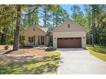 Charming brick home featuring a two-car garage, inviting front porch, and well-manicured lawn at 5750 Nc Highway 49, Burlington, NC 27215