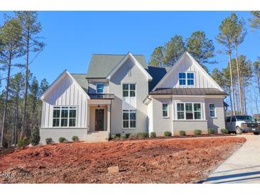 Beautiful two-story home with a brick facade, white trim, and a well-manicured lawn on a sunny day at 7825 Ailesbury Rd, Wake Forest, NC 27587