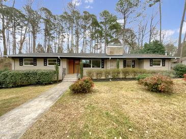 Charming ranch-style home with a brick facade, well-maintained landscaping, and a stone walkway at 106 Woodland Dr, Cary, NC 27513