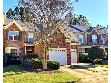 Charming brick townhome featuring a one-car garage and well-manicured landscaping at 11213 Presidio Dr, Raleigh, NC 27617