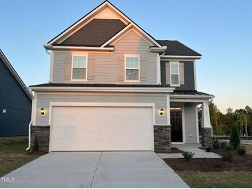 Beautiful two-story home with stone accents, gray siding, and a spacious two-car garage at 135 Willow Cameron Way, Angier, NC 27501