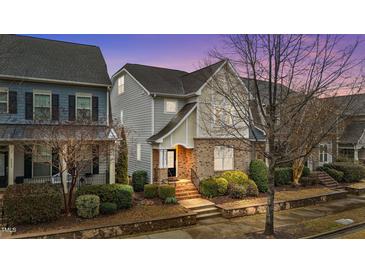 Charming two-story home featuring manicured landscaping and a welcoming brick entryway at dusk at 5618 Wade Park Blvd, Raleigh, NC 27607