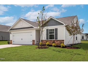 Charming one-story home featuring white siding, stone accents, and a well-manicured lawn at 605 Benton Dr, Oxford, NC 27565