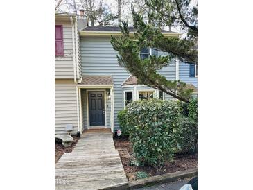 Charming two-story townhome with a rustic wooden walkway to the front door at 6520 Thetford Ct, Raleigh, NC 27615