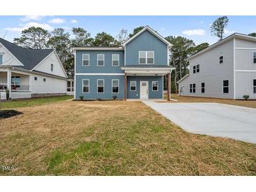 Charming two-story home featuring a spacious front yard and a modern blue facade at O Shortline Rd, Roxboro, NC 27574
