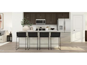 Modern kitchen features stainless steel appliances, granite countertops, and seating for four at the island at 1333 Hazelnut Ridge Ln, Knightdale, NC 27545