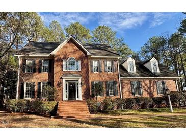 Beautiful brick home featuring manicured landscaping and traditional architectural details at 1809 Waddill Way, Henderson, NC 27536