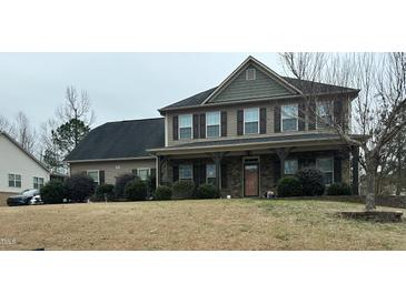 Charming two-story home featuring a covered porch, stone accents, and well-manicured landscaping at 248 Swann Trl, Clayton, NC 27527
