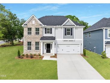 Charming two-story home featuring a brick and siding exterior, a well-manicured lawn, and an attached two-car garage at 376 Buckhorn Branch Park # 38, Clayton, NC 27520