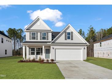New two-story home featuring a well-manicured lawn, gray siding, black shutters, and a two car garage at 617 Spellbrook Rd, Zebulon, NC 27597