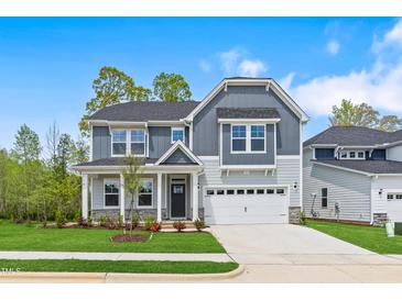 Charming two-story home featuring a well-maintained lawn, covered porch and attached two-car garage at 741 Aristocrat Ln, Knightdale, NC 27545