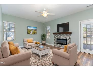 Inviting living room with fireplace, ceiling fan, and comfortable seating arrangement at 89 Bison Ln, Lillington, NC 27546