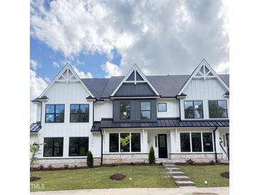 Charming white and gray townhouse featuring manicured lawn and modern architectural details at 905 Myers Point Dr, Morrisville, NC 27560