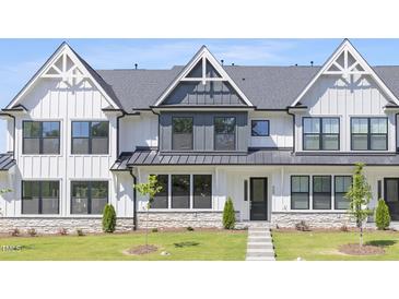 Stylish townhouse with a white facade, gray accents, and a well-manicured lawn at 905 Myers Point Dr, Morrisville, NC 27560