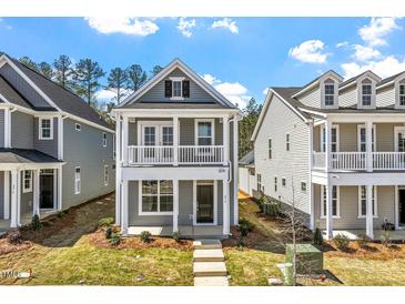 Charming two-story home with a welcoming front porch and balcony, complemented by beautifully maintained landscaping at 272 White Oak Garden Way # 209, Garner, NC 27529
