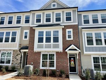 Charming townhome showcasing a brick facade with large windows and a welcoming entrance at 3024 Freewinds Way # 49, Cary, NC 27519