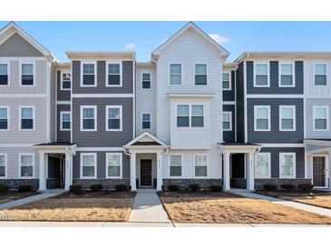 Modern townhome with a mix of white and gray siding, complemented by stone accents on the lower facade at 6318 Perry Creek Rd, Raleigh, NC 27616