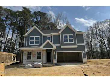 New two-story home featuring a two-car garage, gray siding, white trim, and a classic architectural design at 744 Portland Rose Dr, Knightdale, NC 27545