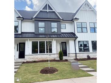 Charming new construction townhome featuring a modern white facade and manicured lawn at 913 Myers Point Dr, Morrisville, NC 27560