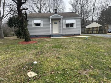 Charming one-story home with light gray siding, awning-covered windows and a simple, inviting front entrance at 104 N Garden Ave, Siler City, NC 27344