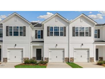 Charming townhomes featuring white siding, black shutters and a single-car garage at 208 Starlight St, Sanford, NC 27330