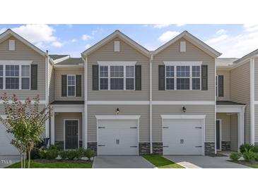 Inviting tan two-story townhome with a single-car garage and attractive landscaping at 216 Starlight St, Sanford, NC 27330
