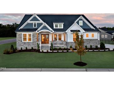 Charming two-story home showcasing stone accents, a covered porch, and manicured lawn at 223 Harvester Rd, Angier, NC 27501